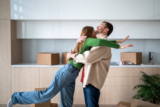Happy wife embracing smiling joyful husband on relocation day into own new apartment, house, flat photo