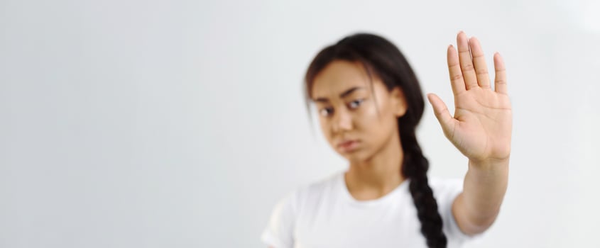 Stop abuse. Asian girl making stop gesture with her palm, grey background photo
