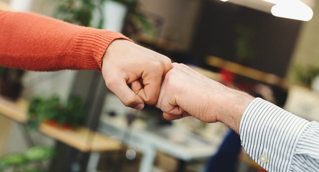 Business partners giving fist bump after complete a deal. Successful teamwork with hands gesture communication. photo