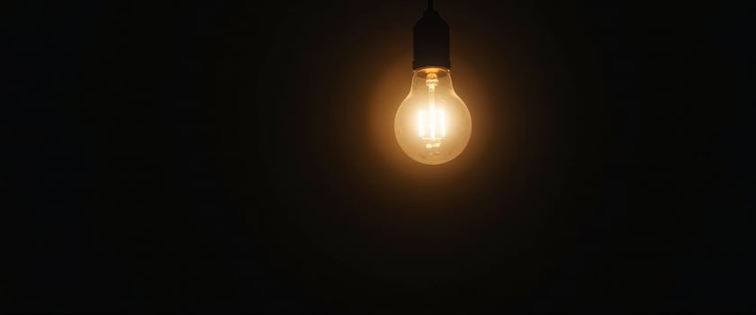 Glowing Light Bulb in Darkness photo