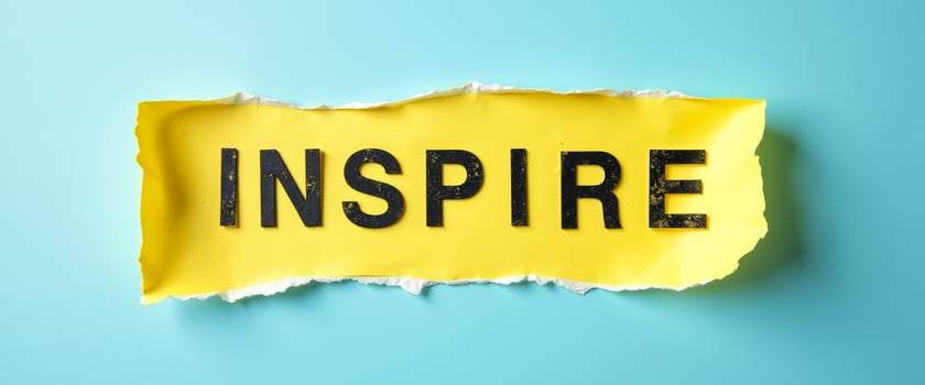 Inspire - Torn Yellow Paper with Black Letters on Blue Background photo