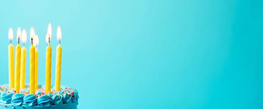 Birthday cake with burning candles on a turquoise background photo