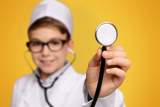 Little friendly doctor ready to examine you, cute boy wearing medical uniform holding stethoscope photo