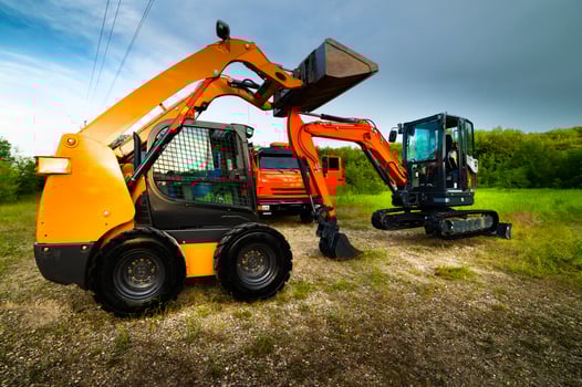 Yellow excavator and truck against green forest, construction equipment. Sale of special equipment photo