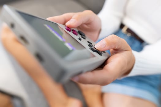 Close-up of female hands of young Caucasian woman holding retro game console. Girl playing retro games on portable game console. Shallow depth of field. Selective focus photo