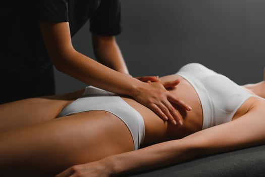 A masseuse woman doing an oil massage to woman on the stomach photo