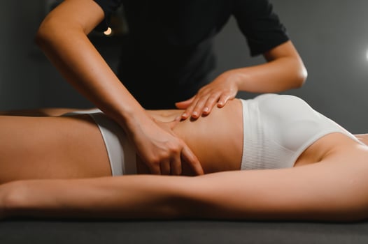 A masseuse woman doing an oil massage to woman on the stomach photo
