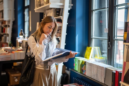 Woman reading, choosing books in bookstore, passionate about literature and bookcrossing on fair photo
