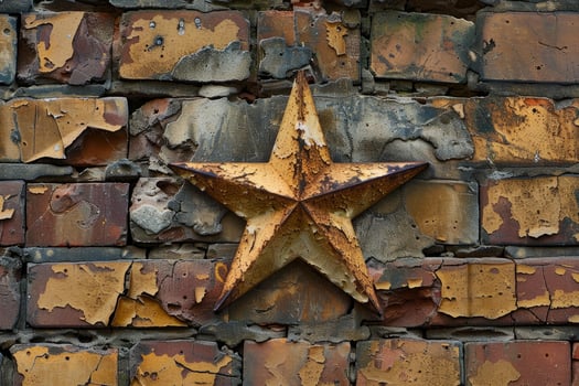 Rusty metal star is mounted on a crumbling brick wall photo