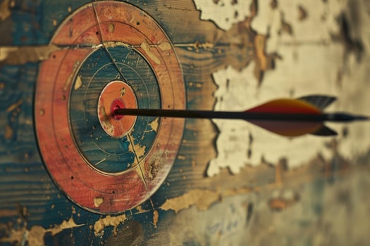 Arrow hitting the center of an old target on a wooden background photo