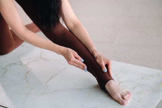 close-up of the legs and arms of a girl who does yoga in a fitness room. Healthy lifestyle, fitness, training, self-care photo