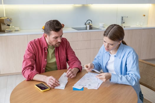 Upset couple manage family budget at home, sorting out papers engaged in expenses, earnings control. photo