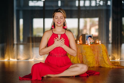 Meditation and concentration. a woman in a red dress sitting on the floor is practicing medicine indoors . Calm and relaxation photo