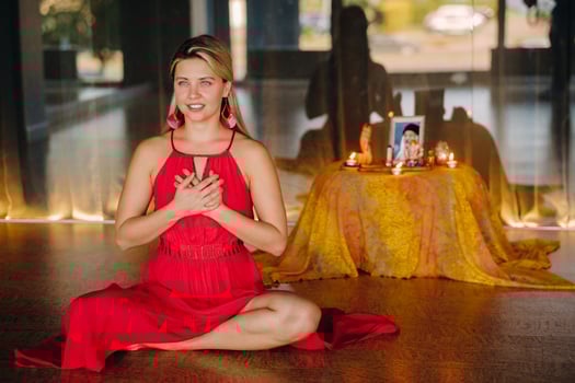 Meditation and concentration. a woman in a red dress sitting on the floor is practicing medicine indoors . Calm and relaxation photo