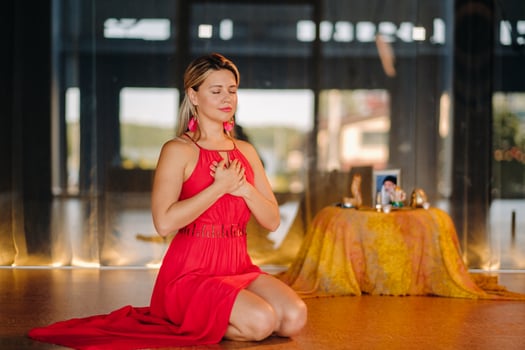 Meditation and concentration. a woman in a red dress, sitting on the floor with her eyes closed, is practicing medicine indoors. Peace and relaxation photo