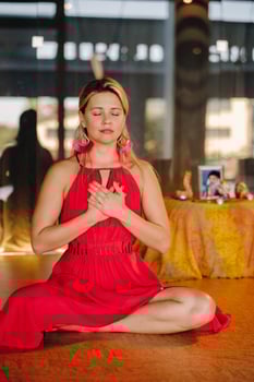 Meditation and concentration. a woman in a red dress, sitting on the floor with her eyes closed, is practicing medicine indoors. Peace and relaxation photo