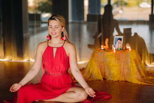 Meditation and concentration. a woman in a red dress, sitting on the floor with her eyes closed, is practicing medicine indoors. Peace and relaxation photo