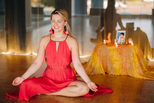 Meditation and concentration. a woman in a red dress, sitting on the floor with her eyes closed, is practicing medicine indoors. Peace and relaxation photo