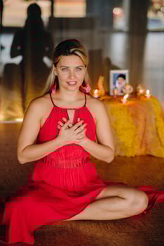 Meditation and concentration. a woman in a red dress sitting on the floor is practicing medicine indoors . Calm and relaxation photo