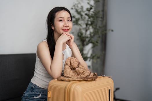 Young Woman Packing Suitcase for Travel, Preparing for Vacation, Organizing Luggage, Ready for Adventure, Smiling and Excited photo