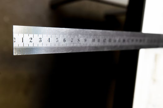 iron ruler with numbers on black background photo