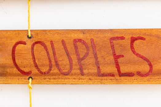Couples inscriptions in red paints on a wooden board suspended on a yellow rope photo