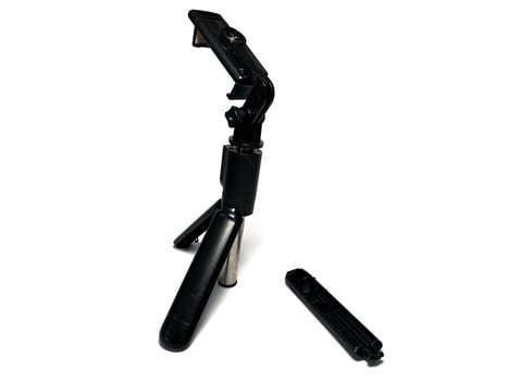 Broken small mobile phone tripod isolated on white background with clipping path. Studio shot. photo