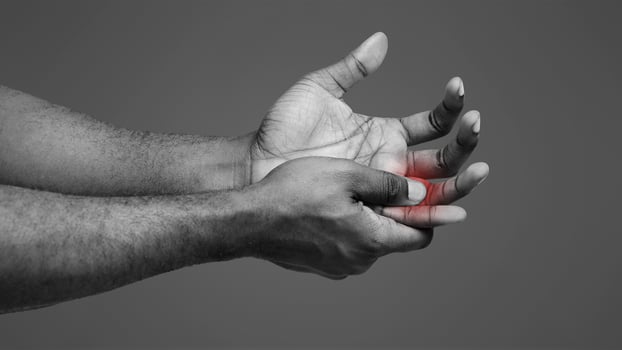 Cropped of man suffering from pain in hand and massaging his painful finger, white background photo