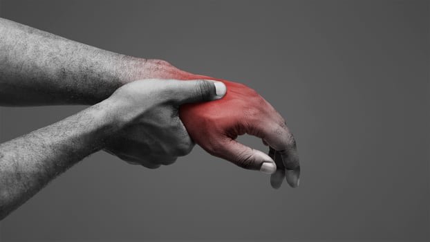 Close up of afro man massaging his highlighted hand, osteoarthritis concept photo