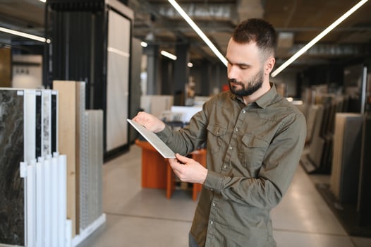 buyer examines ceramic tiles in a construction store photo