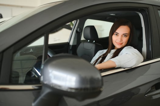 Beautiful young female client customer choosing new car photo