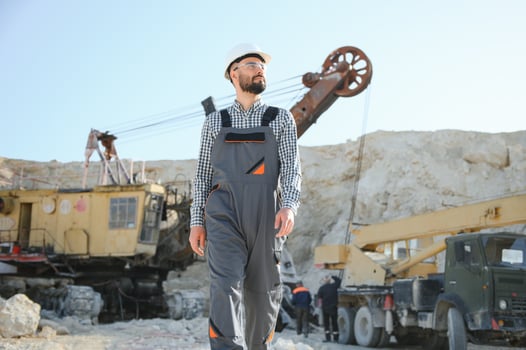 Worker in hardhat standing in stone quarry photo