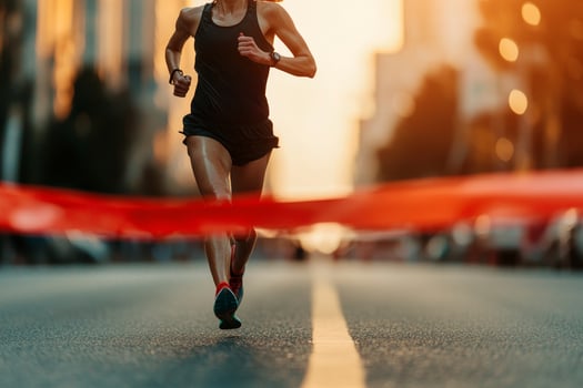 Athletic woman running towards finish line during sunset on urban street. photo