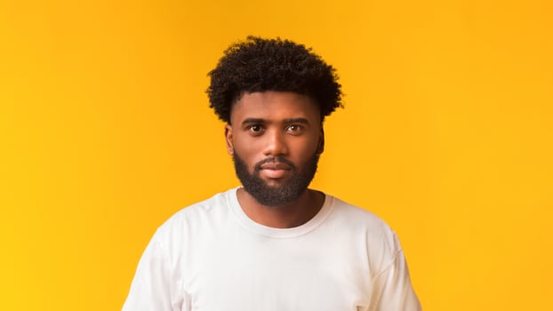Young handsome african american guy over orange studio background photo