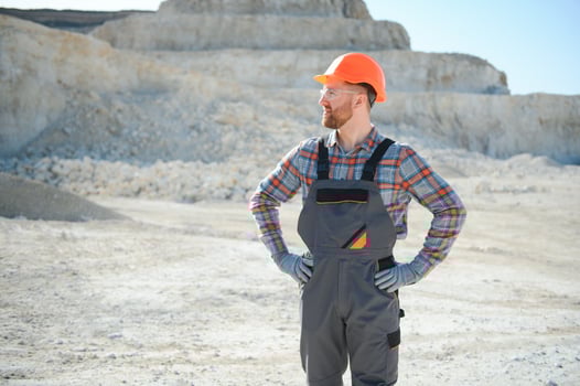 Worker in hardhat standing in stone quarry photo