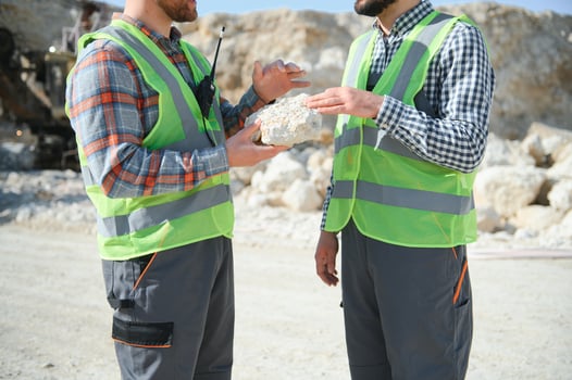 Portrait of stone quarry workers standing on the background of an excavator photo