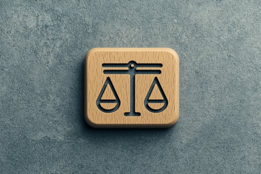 Wooden scales of justice symbol on a textured stone background. photo
