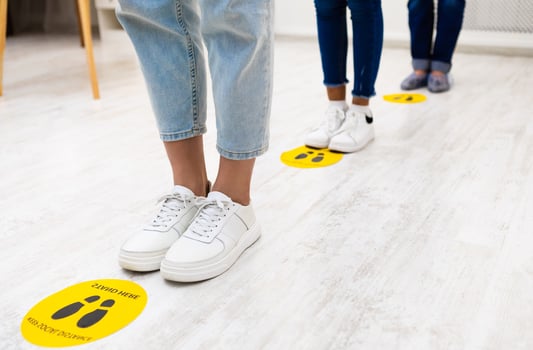 Social Distancing. Unrecognizable People Keeping Safe Distance Standing In Queue Line Waiting For Vaccination In Hospital Indoors. Covid-19 Protection, Coronavirus Pandemic. Cropped, Selective Focus photo