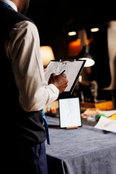 Meticulous fashion designer conceptualizing bespoke sartorial business suit collection in tailoring studio. Creative suitmaker handdrawing sketch of custom made garment piece photo