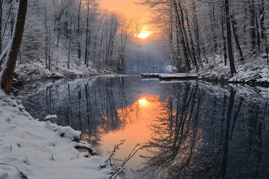 Golden sunset reflecting on a river in the forest during wintertime photo