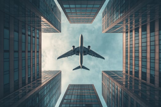 Passenger airplane flying over modern glass buildings photo