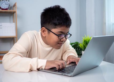 Little Asian boy student using computer laptop learning. Educational of tech concept, Staying at home, Presenting a modern educational way of life. Virtual internet online class from school teacher. photo