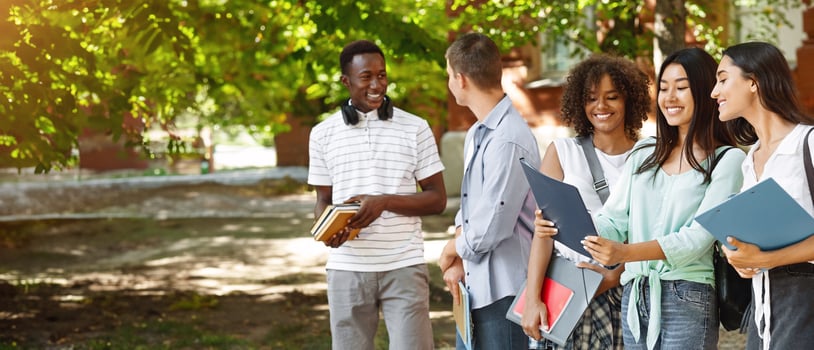 Portrait Of Smiling International Students Standing Outdoors At Campus Courtyard After Classes photo