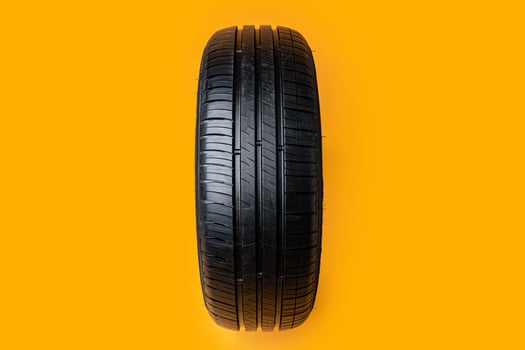 Car tires isolated on yellow background, close up photo