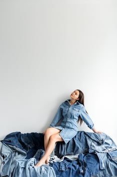 Fashion designer sitting on denim clothes posing for photo shoot