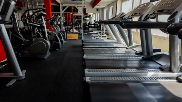 Empty modern gym with rows of treadmills and exercise machines, emphasizing wellness and fitness goals photo