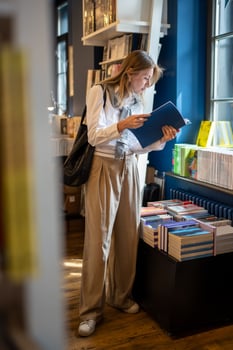 Enthusiastic woman selects books in bookstore alone. Book fair, book crossing, literature passion photo
