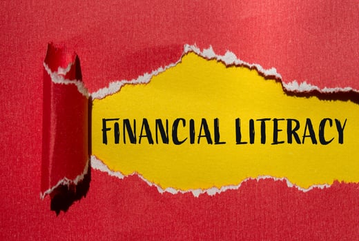 Financial literacy message written on ripped torn red paper with yellow background. Conceptual financial literacy symbol. Copy space. photo