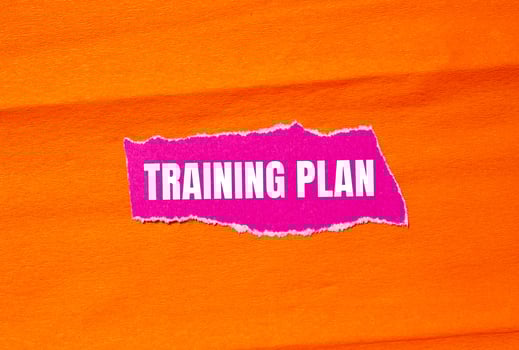 Training plan message written on ripped torn pink paper with orange background. Conceptual training plan symbol. Copy space. photo