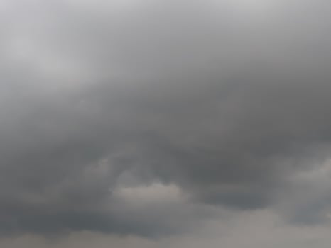 Dark, looming storm clouds dominate the sky, creating a moody, dramatic atmosphere. The overcast sky hints at an impending rainstorm, with thick clouds rolling in and covering the horizon. photo